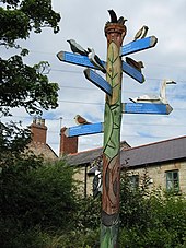 A signpost with bird models on the arms