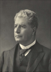 Black and white head and shoulders photograph of well-dressed man