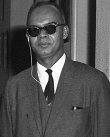 Grayscale portrait of a man in a suit and sunglasses