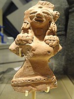 Woman's statue from the Indus Valley Civilization wearing heavy earrings.