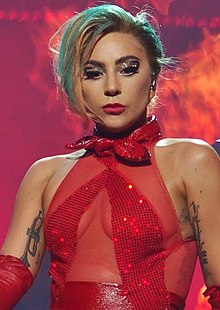Close-up of Lady Gaga performing onstage in a red bodice.