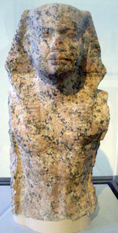 Torso and head of a statue of a king wearing the Egyptian nemes
