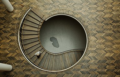 A staircase in Aarhus City Hall, Denmark. The dark grey, kidney-shaped capstone seen at the bottom of the stairwell contains the three foundation stones of the building and was used as the reference point for height adjustment during the entire building period.