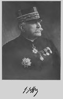 Photographie noir et blanc d'un homme moustachu en uniforme militaire (de nombreuses médailles sont visibles sur son torse) et sa signature sous la photo.