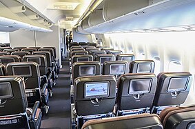 Aircraft main cabin with two aisle and multiple seat rows.