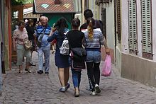 Two adolescents pickpocketing tourists in a pedestrian area
