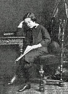 young lad in Victorian dress, sitting at a desk