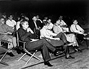 Группа людей в рубашках, сидящих на раскладных стульях
