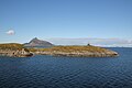 Norwegen: Polarkreiszeichen auf der kleinen Insel Vikingen, im Hintergrund die Felsformation Hestmannen
