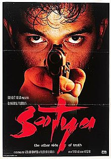 The poster features face of a man behind the revolver he is pointing at the viewer. The film title appears at bottom.