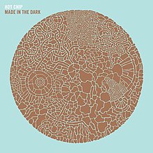 Pale blue album cover embossed with a brown circle made up of smaller parts. The words "Hot Chip" and, below it, "Made in the Dark" are displayed in the top left-hand corner.