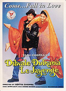 The Dilwale Dulhania Le Jayenge theatrical release poster shows a man in a black leather jacket and blue jeans holding over his shoulders a woman in a red wedding dress. A caption on top reads "Come...Fall in Love".