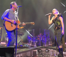 A color picture of singer Gwen Stefani and Blake Shelton performing their song "Go Ahead and Break My Heart" live.