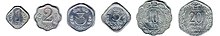 Row of six differently-shaped aluminium coins, arranged by size