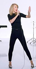 Taylor Swift in the "Shake It Off" music video wearing a black turtleneck