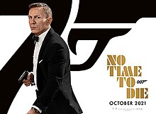 The poster shows Daniel Craig as James Bond dressed in a tuxedo while holding a gun. Behind Bond is the number "7" with a trigger and gun barrel. The film's title is printed in Gold letters with the "007" logo printed next to the word "To". Credits and the film's release date are printed below the title.